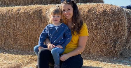 Au pair with child on hay