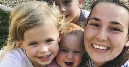 au pair cuddling her three host kids