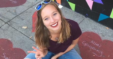 au pair sitting on the ground smiling into the camera