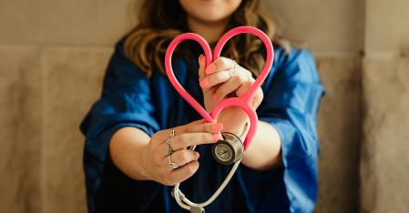 close up of a medical professional shaping a heart with her stethoscope