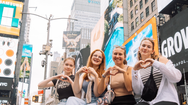 four au pairs sitting on a block in manhattan