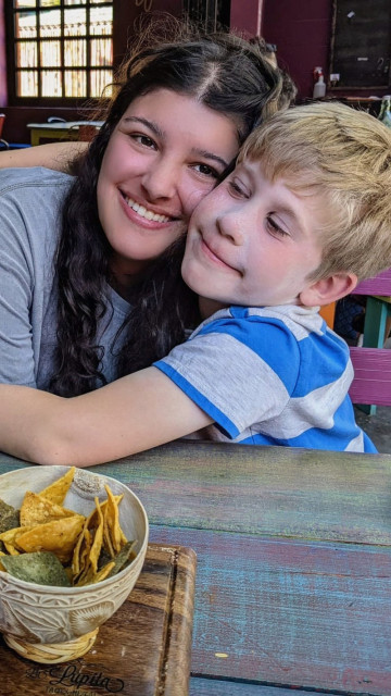 Au pair hugging host child at a restaurant