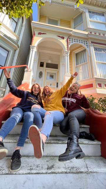 Three au pairs on the steps of a front porch