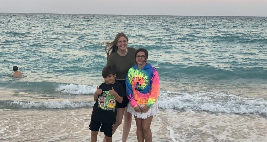 Au pair Laura on vacation in Florida Au pair Laura and her host children hugging by the ocean