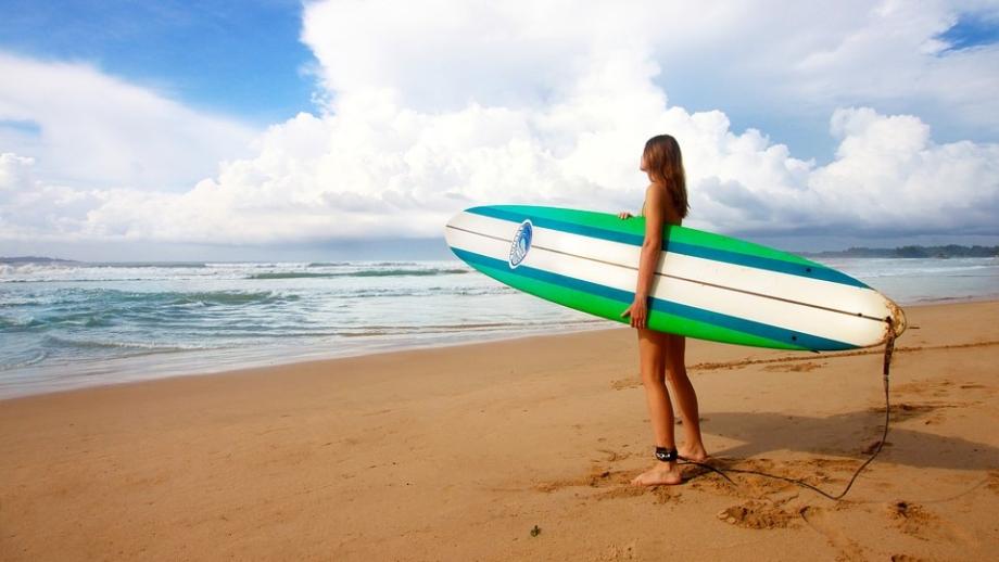 Surfing in Australia girl with surfboard on a beach