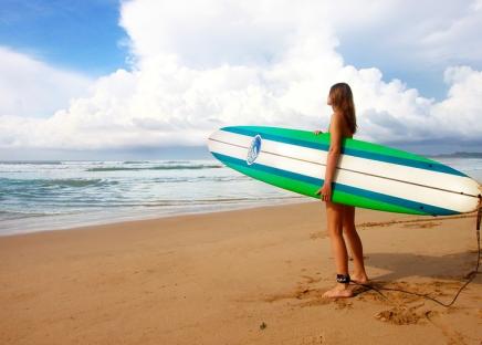 girl with surfboard on the beach
