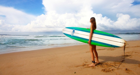 girl with surfboard on the beach